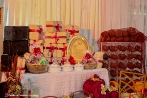 Traditional Wedding, eru iyawo set up for traditional engagement, yam n rack, boxes, baskets, palm oil, gift items for yoruba traditional wedding, parents sofa and couple chairs with green backdrop stage and mirrors with astroturf, event decorator in lagos