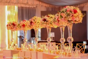 marquee tent venue event center in Lagos, event wedding stage design, signage, chandelier, led dance floor, gold back chameleon chairs, curved VIP table with centerpieces, candles, charger plates, menu card, napkins, event decorator in Nigeria,