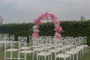 outdoor wedding, wedding day, Church wedding ceremony, vow area outdoor set up with pink and white flower arch, white chameleon back chairs with greenery, Eventigo, Nigerian wedding, event decorator in Lagos