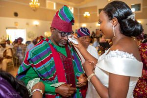 Father and Daughter dance, parents wedding aso oke style, outfit, Debola and Okiki white wedding in Canada, white wedding dress gown, white suit on groom with black pant, buttonnaire, white floral bouquet with memorabilia picture of mum, elegant smile, bridal make up, wrist watch