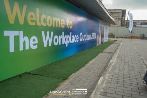 Eventigo The workplace outlook conference, long outdoor false wall for corporate event with green astroturf, photo area