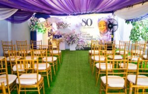 purple and white birthday design for 80th year old grandma with chiavari chairs, green astroturf, flowers